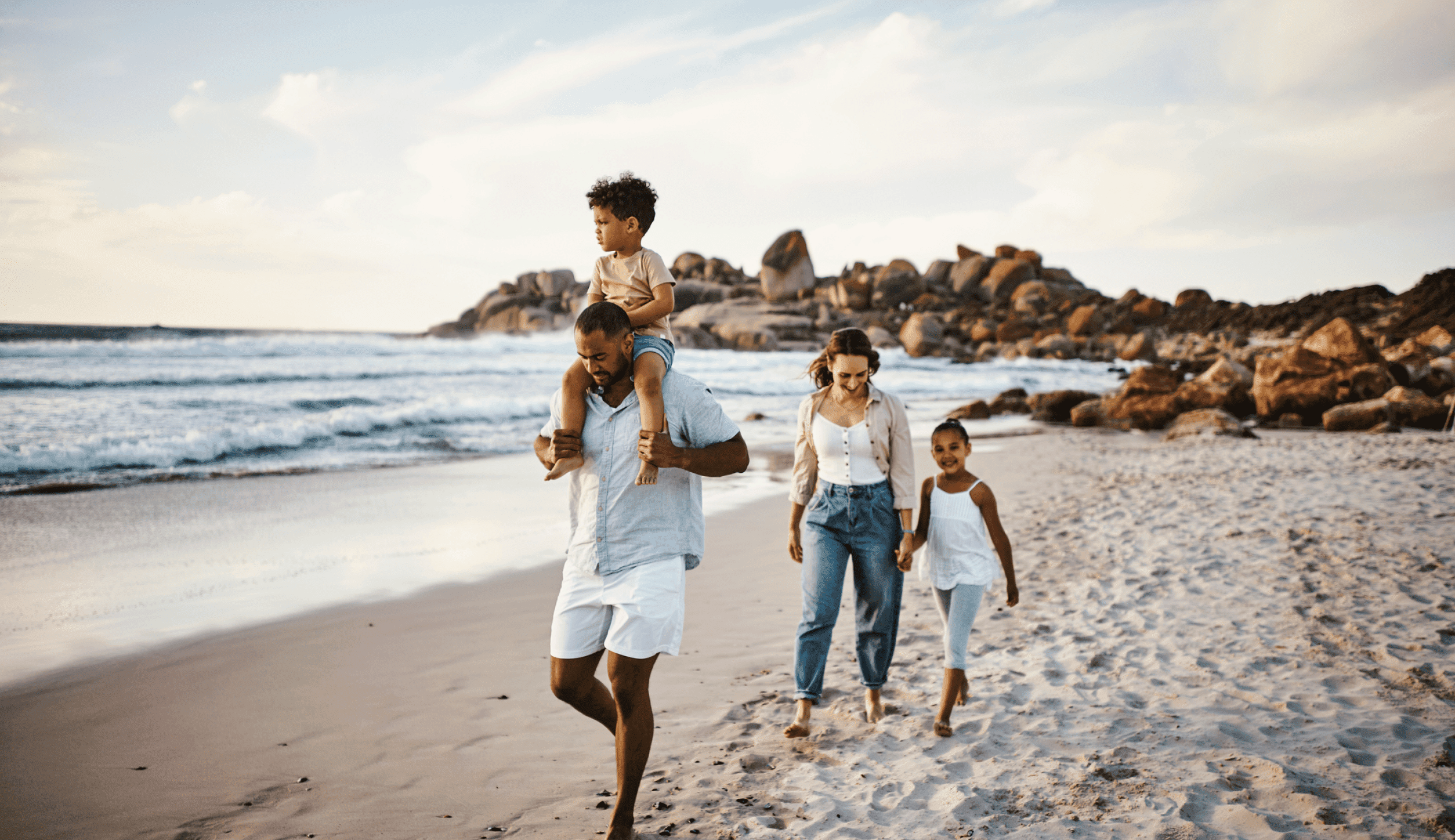 image of a family running across the beach